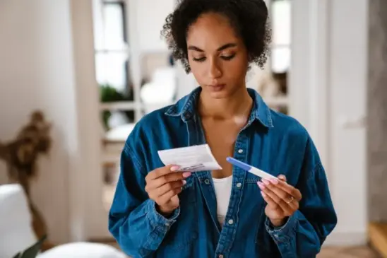 young african american woman holding a pregnancy test